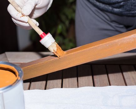 Woman strokes a wooden table with fresh paint