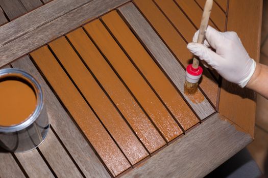 Woman strokes a wooden table with fresh paint