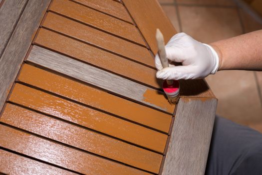 Woman strokes a wooden table with fresh paint