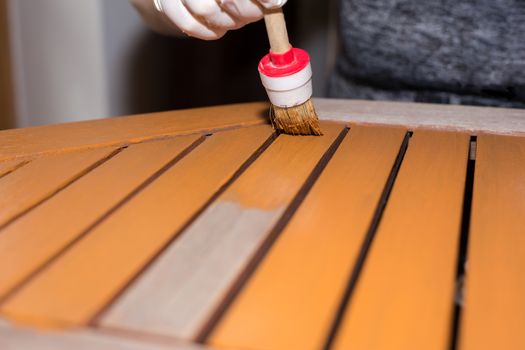 Woman strokes a wooden table with fresh paint