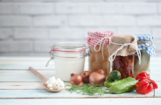 Naturally fermented foods in jars including kefir, gherkins and peppers and onions