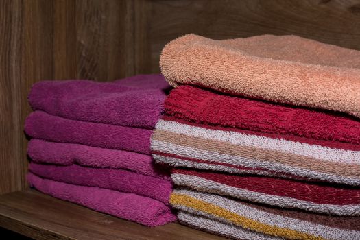 Many colorful towels stacked in the closet