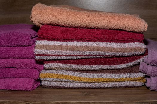 Many colorful towels stacked in the closet