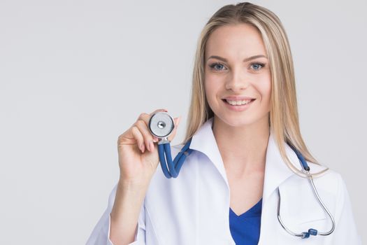 Close up of cheerful happy female doctor listening with a stethoscope