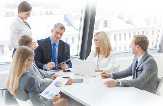 Mixed group of white collar workers at business meeting discuss documents, Business man reading contract at office table