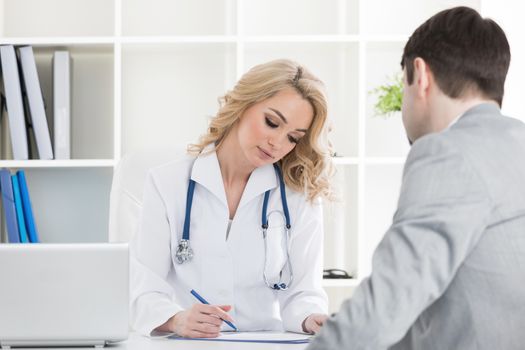 Doctor with patient reading a contract document in clinical office or writing prescription