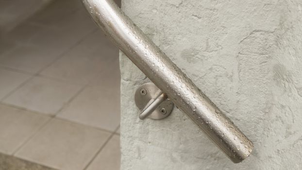 Railing on wall with water drops