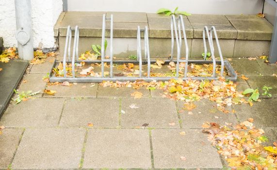 Bicycle rack in front of the house with autumn leaves