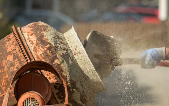 Construction site work with concrete mixer and wheelbarrows