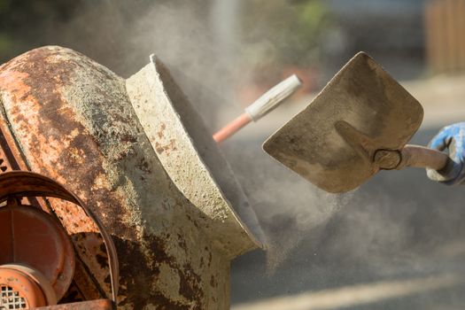 Construction site work with concrete mixer and wheelbarrows