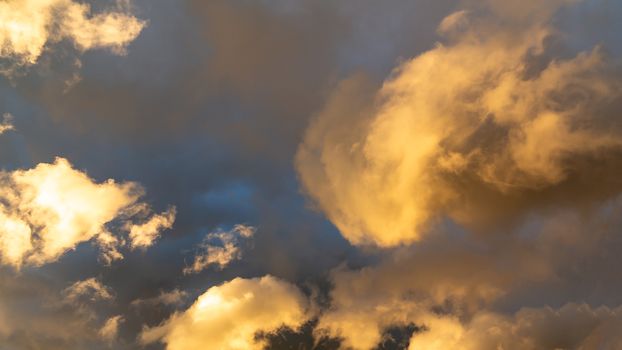 Beautiful cumulus clouds of unusual shape in the blue sky on a summer day.