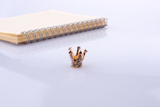 Crown with a notebook on a white background