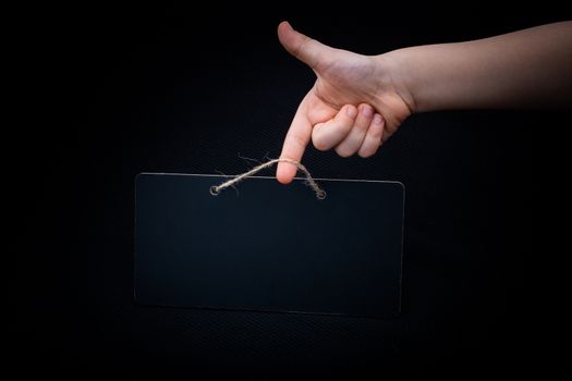 Rectangular shaped black notice board in hand on black background