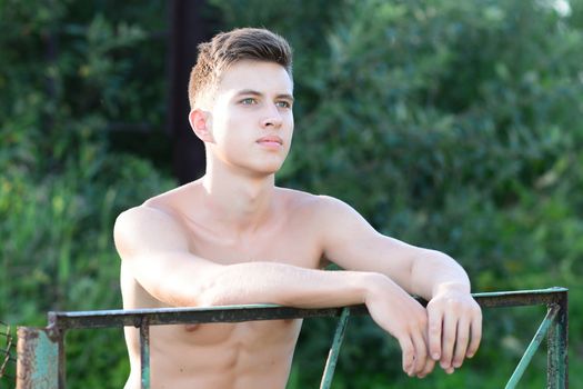 Good looking shirtless fit male model relaxing on the grass