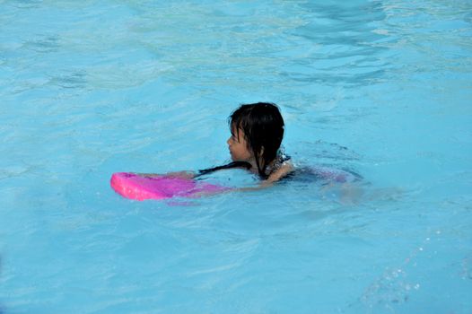 asian little girl playing in the pool