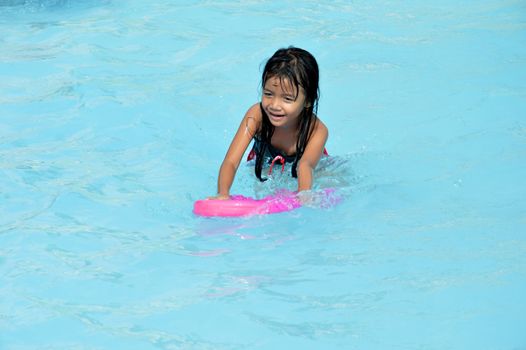 asian little girl playing in the pool