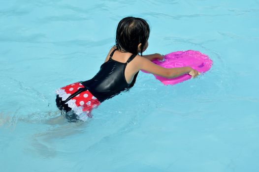 asian little girl playing in the pool