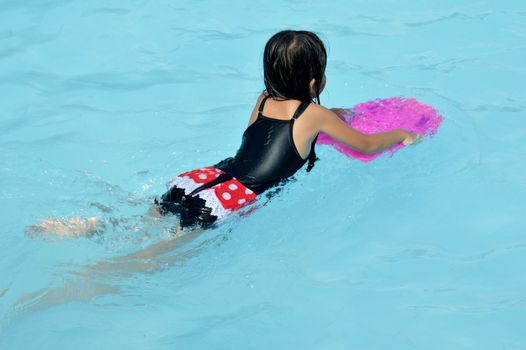 asian little girl playing in the pool