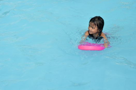 asian little girl playing in the pool