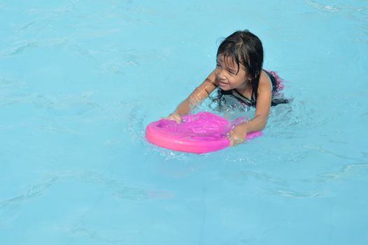 asian little girl playing in the pool