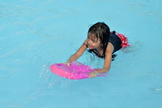 asian little girl playing in the pool