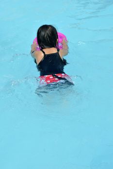 asian little girl playing in the pool