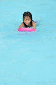 asian little girl playing in the pool