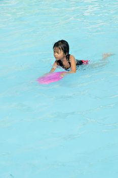 asian little girl playing in the pool