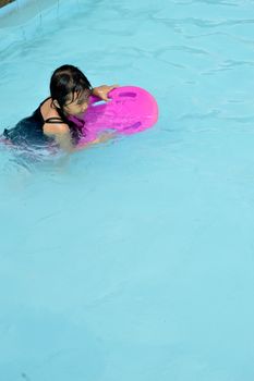 asian little girl playing in the pool