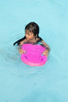 asian little girl playing in the pool