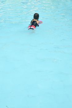 asian little girl playing in the pool