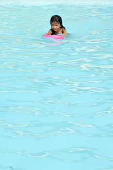 asian little girl playing in the pool