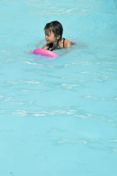 asian little girl playing in the pool