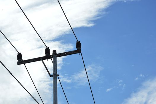 electricity poles against blue sky