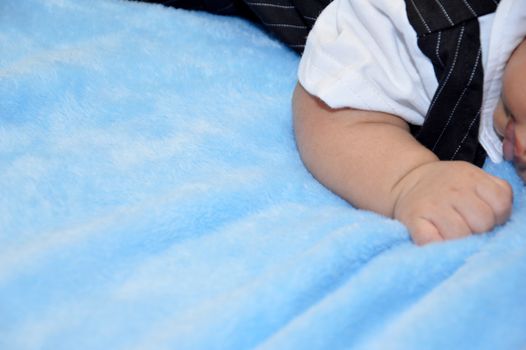 close up baby's hands lying on the velvet carpet