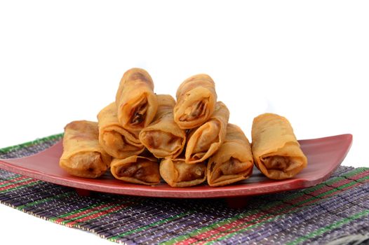 lumpia Semarang or Spring Rolls containing bamboo shoots and chicken on red plate at white background 