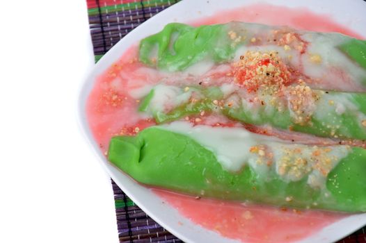 pisang ijo ice or green banana ice a tradisonal snack foods from ethnic Bugis or Makassar made of ripe banana pancakes wrapped in pandan leaf extract gravy with fla, syrup,milk and peanut powder