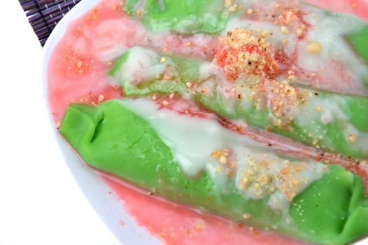 pisang ijo ice or green banana ice a tradisonal snack foods from ethnic Bugis or Makassar made of ripe banana pancakes wrapped in pandan leaf extract gravy with fla, syrup,milk and peanut powder