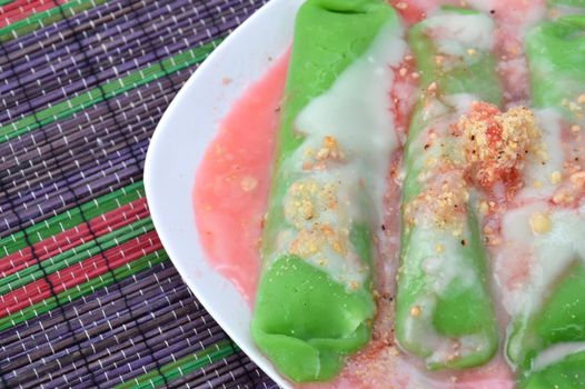 pisang ijo ice or green banana ice a tradisonal snack foods from ethnic Bugis or Makassar made of ripe banana pancakes wrapped in pandan leaf extract gravy with fla, syrup,milk and peanut powder