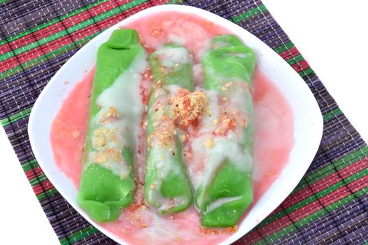 pisang ijo ice or green banana ice a tradisonal snack foods from ethnic Bugis or Makassar made of ripe banana pancakes wrapped in pandan leaf extract gravy with fla, syrup,milk and peanut powder