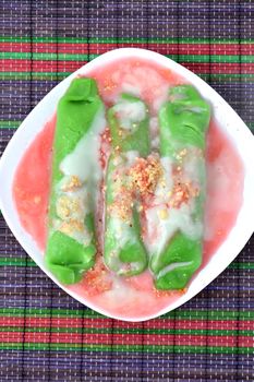 pisang ijo ice or green banana ice a tradisonal snack foods from ethnic Bugis or Makassar made of ripe banana pancakes wrapped in pandan leaf extract gravy with fla, syrup,milk and peanut powder