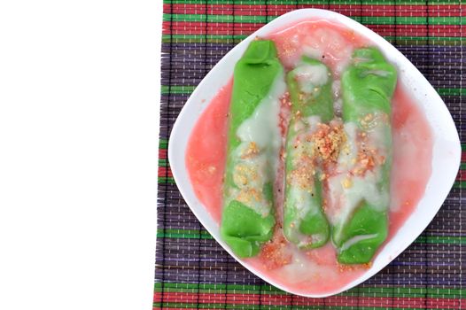 pisang ijo ice or green banana ice a tradisonal snack foods from ethnic Bugis or Makassar made of ripe banana pancakes wrapped in pandan leaf extract gravy with fla, syrup,milk and peanut powder