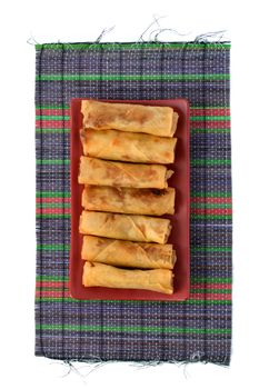 lumpia Semarang or Spring Rolls containing bamboo shoots and chicken on red plate at white background 