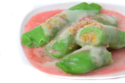 pisang ijo ice or green banana ice a tradisonal snack foods from ethnic Bugis or Makassar made of ripe banana pancakes wrapped in pandan leaf extract gravy with fla, syrup,milk and peanut powder