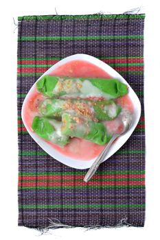 pisang ijo ice or green banana ice a tradisonal snack foods from ethnic Bugis or Makassar made of ripe banana pancakes wrapped in pandan leaf extract gravy with fla, syrup,milk and peanut powder