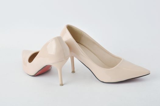 beige high heel shoes on white background