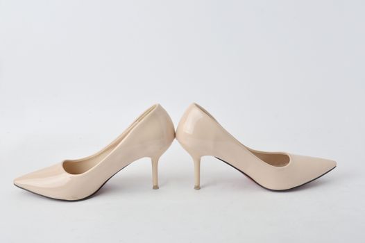 beige high heel shoes on white background