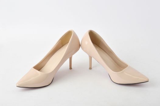 beige high heel shoes on white background