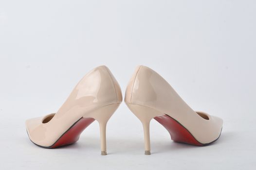 beige high heel shoes on white background