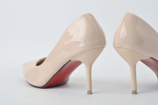 beige high heel shoes on white background